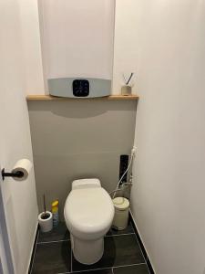 ein Bad mit einem WC und einem TV darüber. in der Unterkunft Appartement lumineux et cosy au cœur de Lille in Lille
