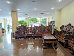 um grupo de cadeiras de madeira num quarto em 中青秋果酒店 True Go Hotel em Phnom Penh