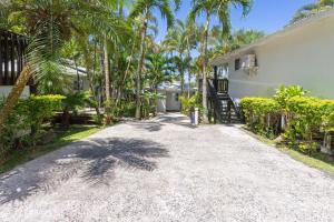 una entrada que conduce a una casa con palmeras en Muri Lagoon View Bungalows - Hillside Bungalow en Rarotonga