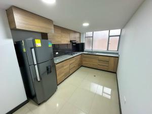 a kitchen with a stainless steel refrigerator and wooden cabinets at Apto 401 / Av. Las Lajas in Ipiales