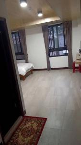 a room with two beds and a television and a rug at Beautiful Guest House II in Chin-sha