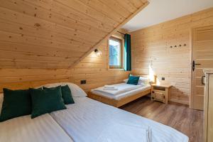 a bedroom with two beds in a wooden cabin at Domki Tatrzański Przystanek in Białka Tatrzańska