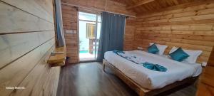- une chambre avec un lit dans une cabane en bois dans l'établissement Sand Tent Beach House PALOLEM, à Canacona