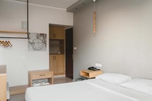 メッシーニにあるMessini Hotelの白いベッドと木製キャビネット付きのベッドルーム1室