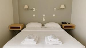 a bedroom with a bed with towels on it at Messini Hotel in Messini