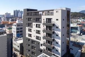 un grand bâtiment blanc avec un panneau d'hôtel dans l'établissement Jin Arirang Hostel, à Yeosu