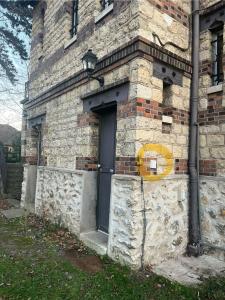 um edifício de tijolos com uma porta com um círculo amarelo em Studio au vert ! em Le Vésinet