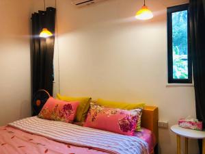 a bedroom with a bed with colorful pillows at Simple Garden Resort in Koh Phangan