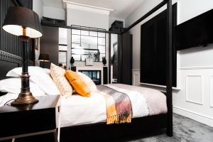 a black and white bedroom with a bed and a lamp at East Cliff in Preston