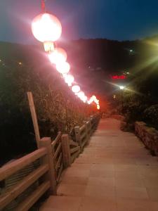 a row of street lights on a fence at night at Beautiful Guest House II in Chin-sha