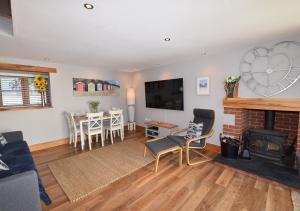 a living room with a fireplace and a dining room at The Stables in Braunton