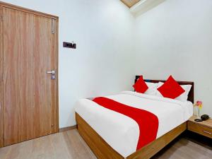 a bedroom with a large bed with red pillows at Malali Residency in Mumbai