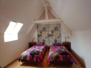 a attic room with two beds and a window at Gostifrance in Milhac