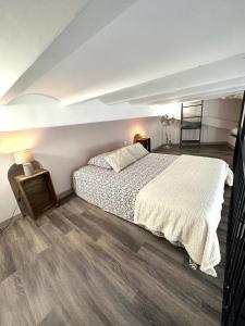 a bedroom with a large bed and wooden floors at Les Platanes in Cassis