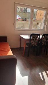 a table and chairs in a room with a window at Apartman Lami in Tuzla