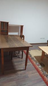 a wooden table and chairs in a room at Apartman Lami in Tuzla