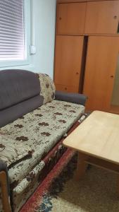 a couch sitting in a living room next to a table at Apartman Lami in Tuzla