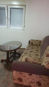a living room with a bed and a table at Apartman Lami in Tuzla