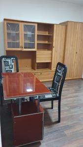 a room with a table and a chair and cabinets at Apartman Lami in Tuzla