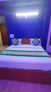 een groot bed in een kamer met een blauwe muur bij Hotel The Grace Near Delhi Airport in New Delhi