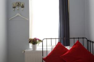 a bedroom with a bed with red pillows and a window at Cheers Porthouse in Istanbul