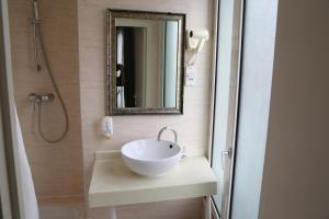 bagno con lavandino e specchio di Hôtel Princesse Isabelle a Puteaux