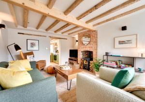 a living room with two couches and a fireplace at No.1 Baileygate Cottages in Castle Acre