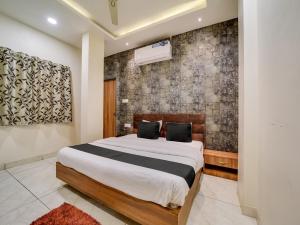 1 dormitorio con cama y pared en Collection O Zamzam Residency, en Bhopal