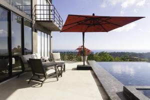 a patio with a table and an umbrella next to a pool at Prime Hermosa- Ocean View Villa with Infinity Pool in Playa Hermosa