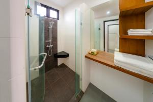 uma casa de banho com um chuveiro e uma cabina de duche em vidro. em Nongnooch Garden Pattaya Resort em Ban Nong Chap Tao