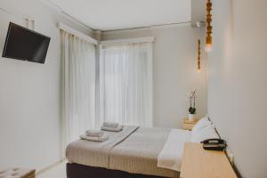 メッシーニにあるMessini Hotelのベッドルーム1室(ベッド1台、壁にテレビ付)