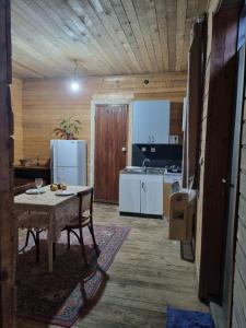 Il comprend une cuisine équipée d'une table et d'un réfrigérateur. dans l'établissement Lux Apartment Tea, à Akhaltsikhé