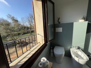 ein Bad mit einem WC und einen Balkon mit einem Fenster in der Unterkunft Affittacamere Ca' de Mazapedar 