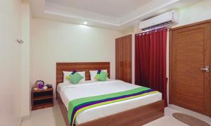 1 dormitorio con cama y cortina roja en Itsy By Treebo - Elite Inn, en Chennai