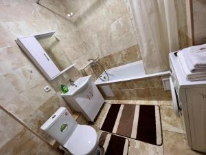 een badkamer met een toilet en een wastafel bij Апартаменты напротив спорткомплекса Алматы Арена 81-29 in Alma-Ata