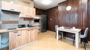 a kitchen with wooden cabinets and a table with chairs at Eleven in Karpacz