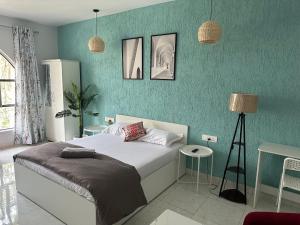 Un dormitorio con una cama y una pared azul. en Azure : Private Studio in Koregaon Park, en Pune