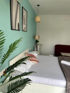 Un dormitorio con una cama blanca con una pared verde. en Azure : Private Studio in Koregaon Park, en Pune