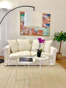 a living room with a white couch and a table at Susannas Lovely New Apartment in Livorno
