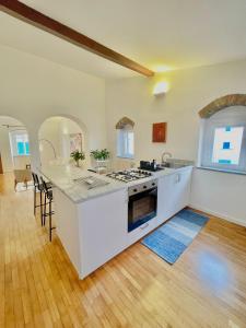 a kitchen with white appliances and a wooden floor at Susannas Lovely New Apartment in Livorno
