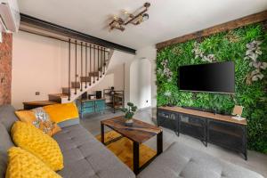 a living room with a couch and a flat screen tv at Deluxe House Maj in Brežice