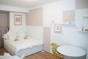 a white bedroom with a bed and a table at Cozy City Apartments in center K28 in Vienna