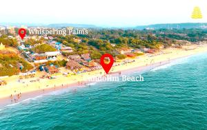 - une vue aérienne sur une plage avec un groupe de personnes dans l'établissement Whispering Palms Beach Resort, à Candolim