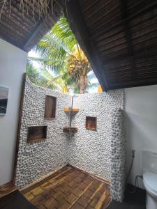 a bathroom with a toilet and a cross on the wall at U Story Resort in Siquijor