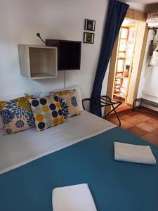 a bedroom with a bed and a tv on the wall at House SoleSiculo in Siracusa