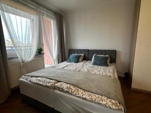 um quarto com uma cama com duas almofadas e uma janela em Apartament Studio Kamienna street em Breslávia