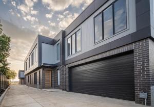a house with a black garage door on it at Elegance and Style in Wagga Wagga