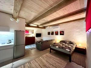 a living room with a bed and a refrigerator at Valgeranna Apartment in Pärnu