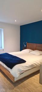 a bedroom with a large bed with a blue wall at Le jardin bernard PERRIER in Montbazin