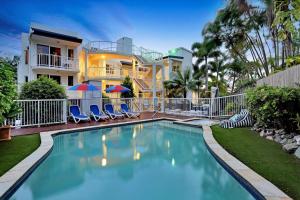 a swimming pool in front of a house at Ocean Vista On Alex in Alexandra Headland